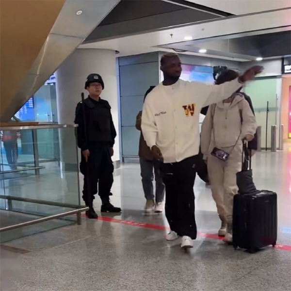 国足归化热门奥斯卡现身昆明：球迷接机盛景，微笑比心展亲和